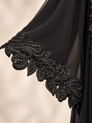 Close-up of 3D floral embellishments and lace HAND on a black net open abaya