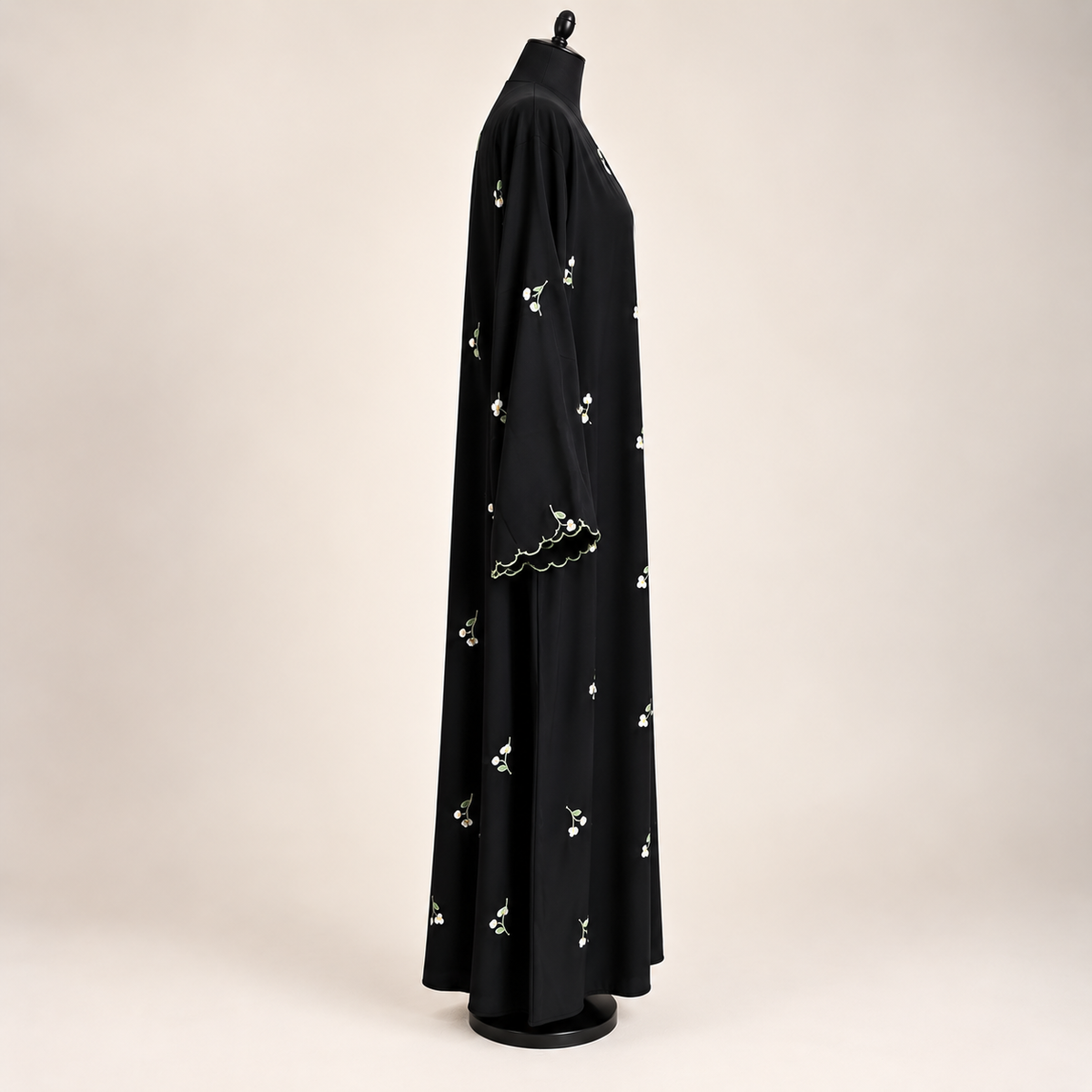 Front view of a black closed abaya with delicate dainty floral embroidery and matching scarf