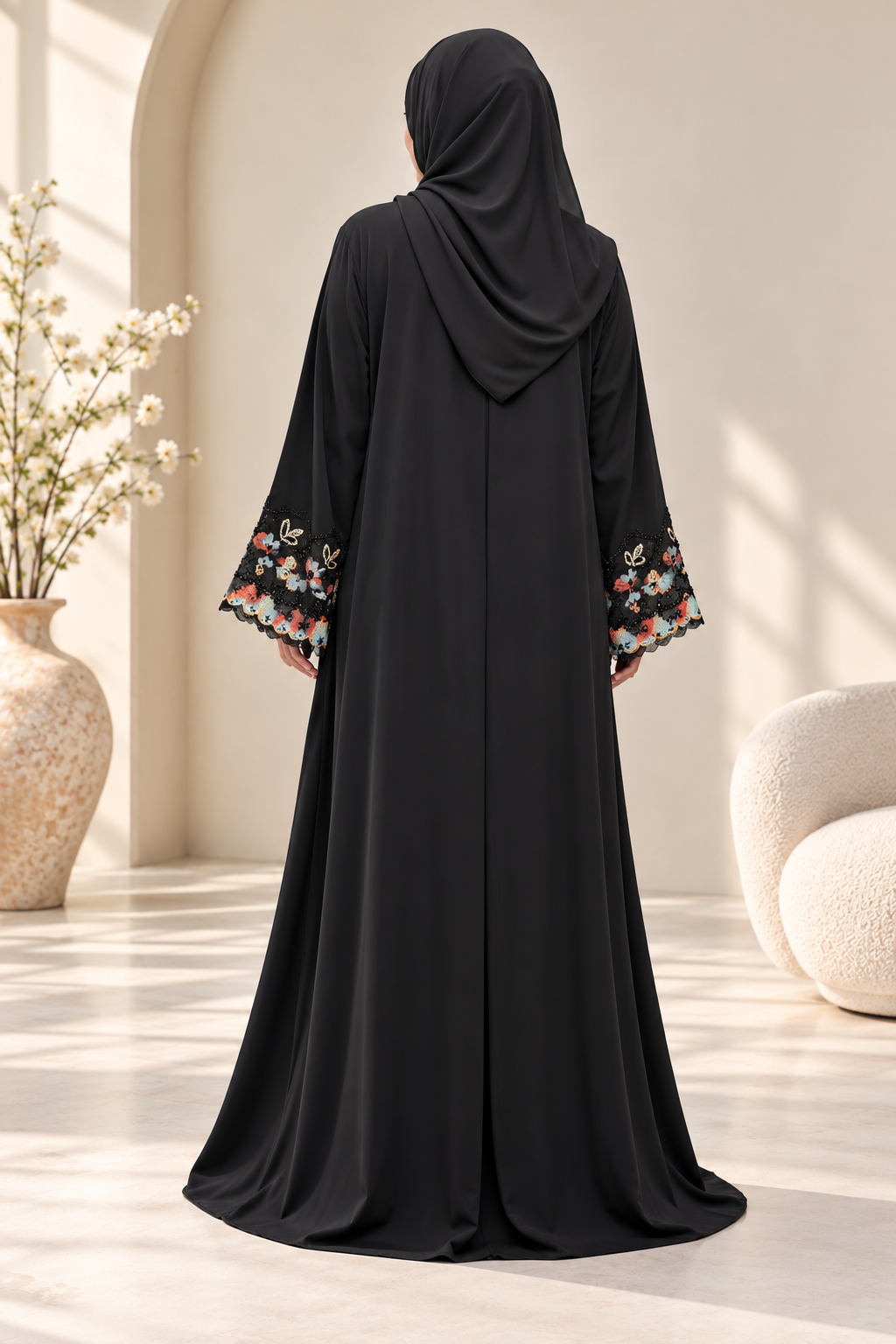 Back view of a black open abaya featuring colourful floral embroidered sleeves with scalloped detailing and a matching black hijab.emarati.co.uk