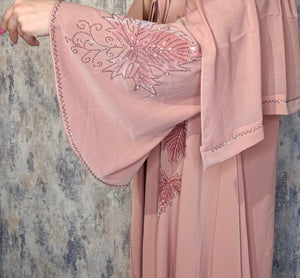 Close-up of decorative stone work on the dusty blush pink Reem open abaya